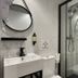 CC Opera Suites bathroom in Madrid with glass shower enclosure, wall mirror, and white sink