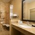 Hampton Inn Battle Creek bathroom with roll-in shower, grab bars, vanity and large mirror