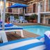Hotel Posada De Roger in Puerto Vallarta with a courtyard pool, blue umbrellas, and lounge chairs