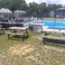 Village Green Motel in South Yarmouth with picnic tables beside an outdoor pool and lounge chairs
