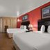 Quality Inn Wayne - Fairfield Area room with two beds, desk, TV and red accent wall in Wayne