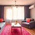 Taks-Inn Suites Istanbul living room with sofa, armchair, coffee table, rug and window curtains