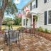 The Capitol Inn in Tallahassee with outdoor patio seating beside a white inn and flags