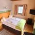 Pension Göschlberger in Mondsee room with double bed, window, wood flooring, and wall-mounted TV
