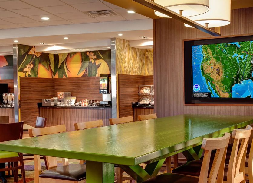 Fairfield Inn & Suites by Marriott Batesville lobby with large green table and wall-mounted TV
