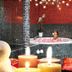Landhotel Christopherhof in Grafenwiesen: candlelit spa bath with mosaic tiles and a woman relaxing in the tub.