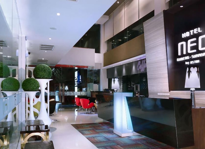 Hotel Neo Gubeng Surabaya lobby with modern reception desk and red chairs