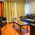 Gran Hotel Paris in La Ceiba living room with leather sofas, coffee table and curtained window