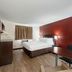 Red Roof Inn Bristol guest room with king bed, desk, and red accent wall in Bristol