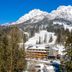 mama thresl in Leogang with a snowy alpine mountain backdrop and forested slopes