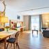 Das Bergmayr - Chiemgauer Alpenhotel in Inzell: bright suite with sofa, dining table, balcony door and mountains view