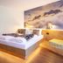 Das Bergmayr - Chiemgauer Alpenhotel room in Inzell with mountain mural, bed and bench seating