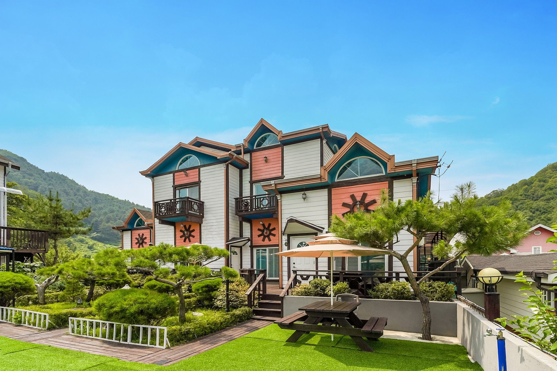 Gapyeong Ola Pension in Gapyeong with landscaped garden, outdoor seating and mountain backdrop