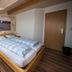 Hotel Panorama Garni in Heligoland bedroom with skylight, wood bed, stone accent wall and sea photo