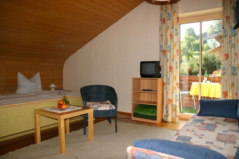 Pension Hoisl in Schönberg: cozy room with twin beds, TV, seating area and balcony door to garden