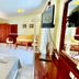 Venardos Hotel in Agia Pelagia guest room with twin beds, seating area, and wall-mounted TV