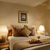 Orchard Point Serviced Apartments in Singapore bedroom with king bed, bedside lamps, and vanity desk