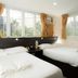 Homy Inn in Hong Kong twin room with large windows and beige curtains