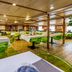 Botel Marina in Rijeka dining room with green chairs, white tablecloths and wood-paneled ceiling