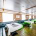 Botel Marina in Rijeka dining room with long tables, green chairs, and wood-paneled interior