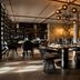 Schlosshotel Fiss in Fiss dining room with round tables, dark chairs, bar shelves, and modern chandelier