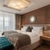 Schlosshotel Fiss in Fiss: elegant bedroom with king bed, wood-paneled wall and balcony view