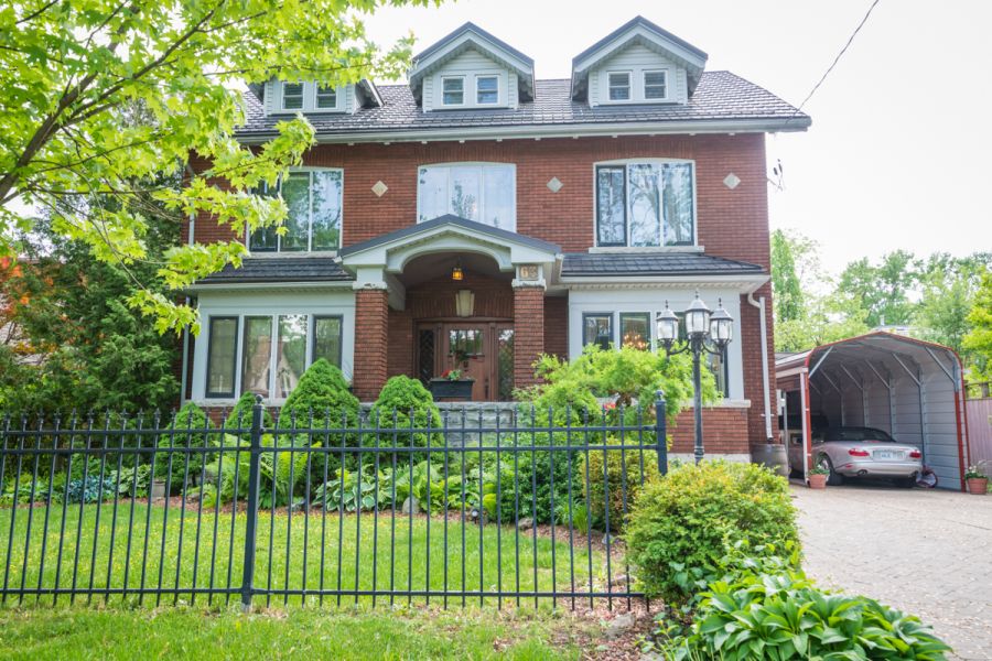 Avonview Manor in Stratford, brick manor house with front garden, black fence and driveway
