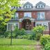 Avonview Manor in Stratford, brick manor house with front garden, black fence and driveway