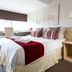 Holtwhites Hotel in Enfield guest room with double bed, red accents, and a window-side desk