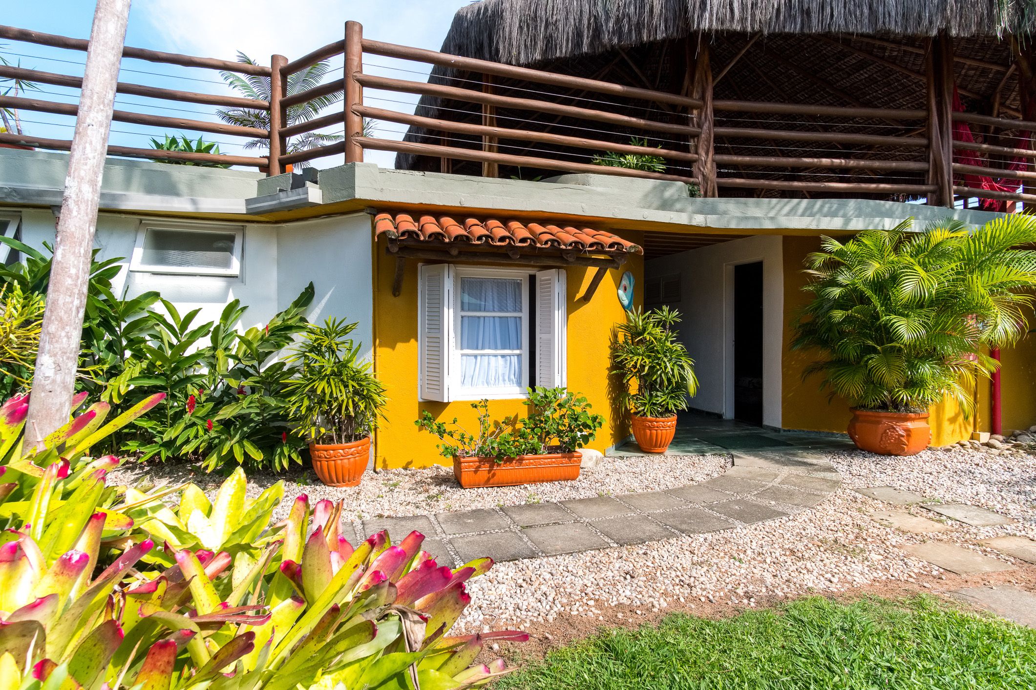 Pousada Recanto das Palmeiras Ubatuba - Itagua exterior with tropical plants and thatched-roof terrace