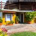 Pousada Recanto das Palmeiras Ubatuba - Itagua exterior with tropical plants and thatched-roof terrace