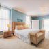 Somerset House Boutique Hotel and Restaurant room in Southsea with tufted bed, blue walls, and tall windows