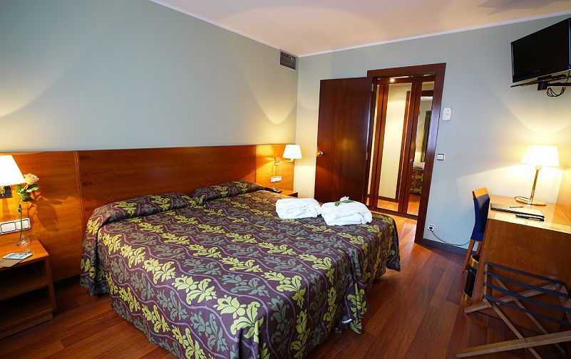 Zenit Diplomatic in Andorra la Vella guest room with double bed, desk, lamps and wood flooring
