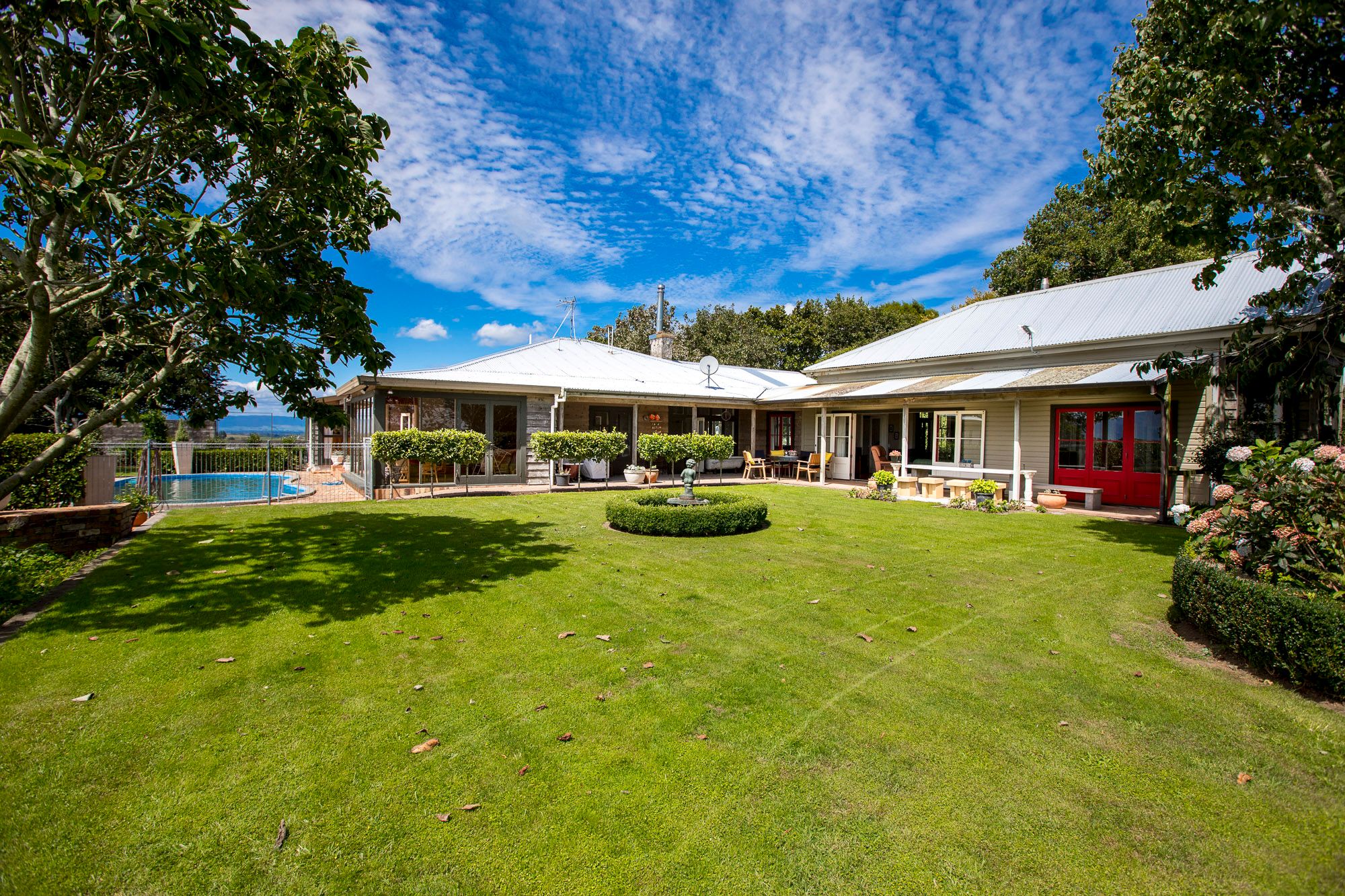 Ngapuke Farm Matamata in Matamata with a large green lawn, pool, and single-story lodge buildings