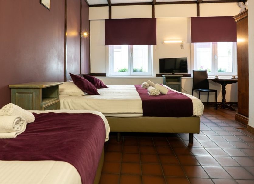 Flandria Hotel in Ghent guest room with two beds, desk, TV and tiled floor