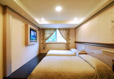 Alishan Shermuh Hotel in Chiayi City guest room with two beds and a window with curtains