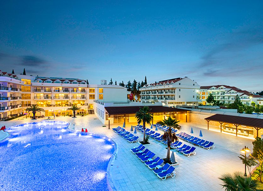 Kemer Dream Hotel in Kemer with illuminated outdoor pool and rows of blue loungers