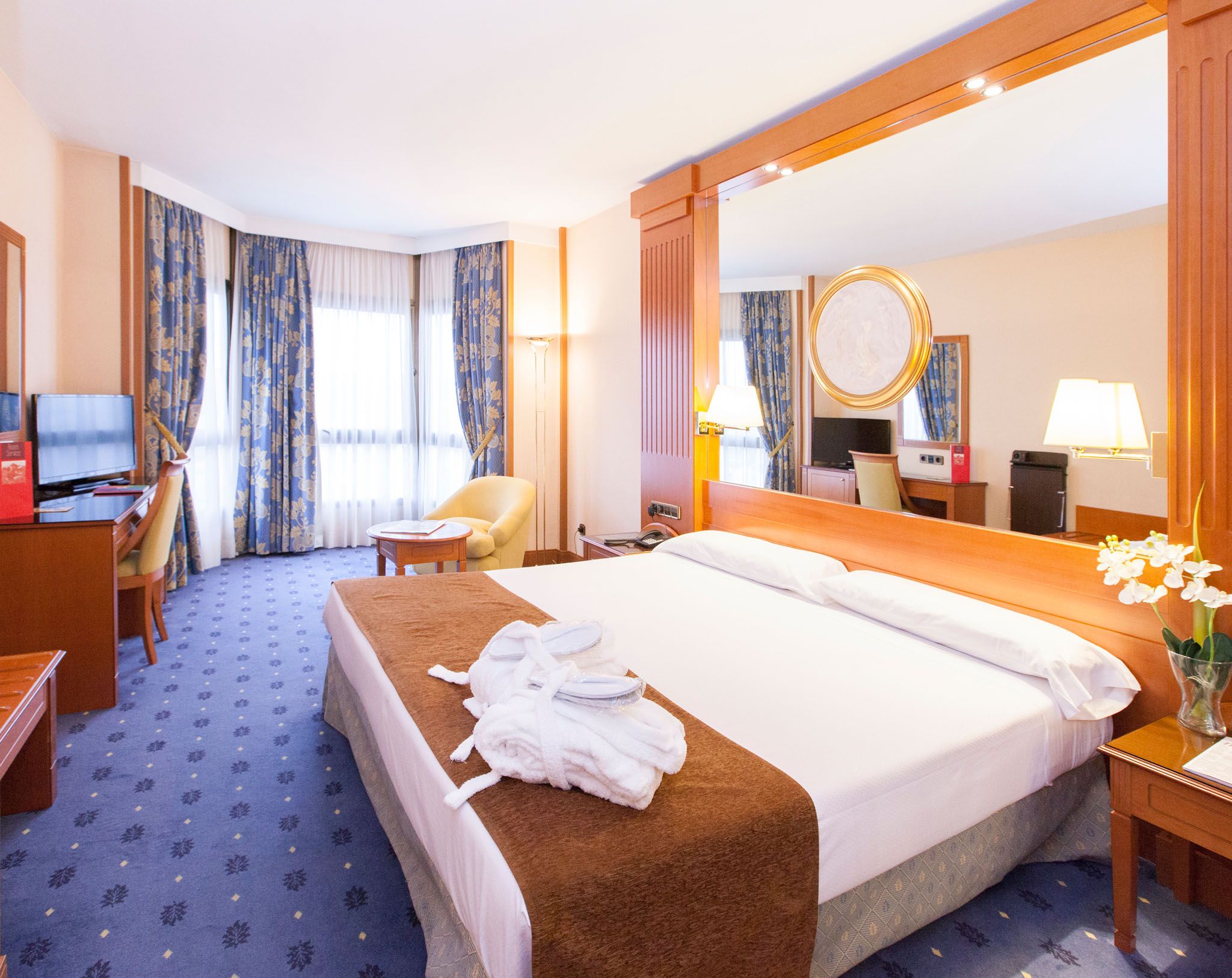 Hotel los Bracos room in Logroño with large bed, sitting area, and floor-to-ceiling window