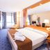 Hotel los Bracos room in Logroño with large bed, sitting area, and floor-to-ceiling window