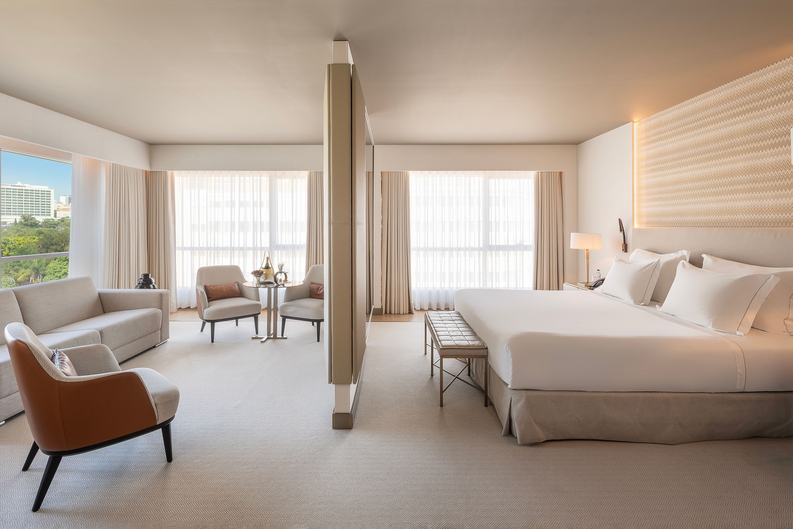 Epic Sana Marques Hotel Lisbon suite with king bed, seating area and large windows with city views