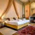 Hotel Jan Brito Bruges guest room with canopy bed and ornate fireplace