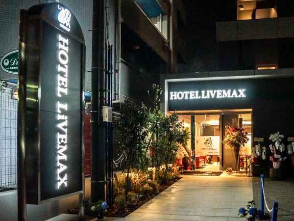 Hotel Livemax Saitama-Asaka-Ekimae entrance at night in Asaka with illuminated sign and walkway