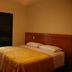 Piemonte Flat Serra Negra Sp room with bed, balcony door, and countryside view in Serra Negra