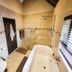Blue Hills Lodge in Johannesburg bathroom with freestanding tub, walk-in shower and tiled walls