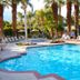 The Oasis, Palm Springs hotel pool with palm trees and lounge chairs in a sunny courtyard