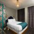 The Wicker Park Inn Chicago room with floral accent wall, queen bed, and dark curtains