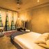 Kapievi Ecovillage in Puerto Maldonado, bedroom with bed, seating area, and large window curtains