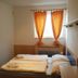 Sporthotel Vestec room with twin beds, orange curtains, and a small window in Vestec