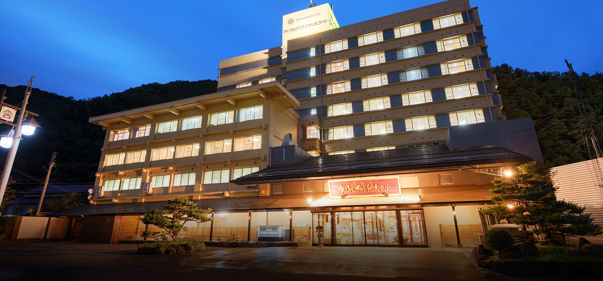 Ashinomaki Grand Hotel in Aizuwakamatsu at dusk, showing a multi-story exterior with lit windows