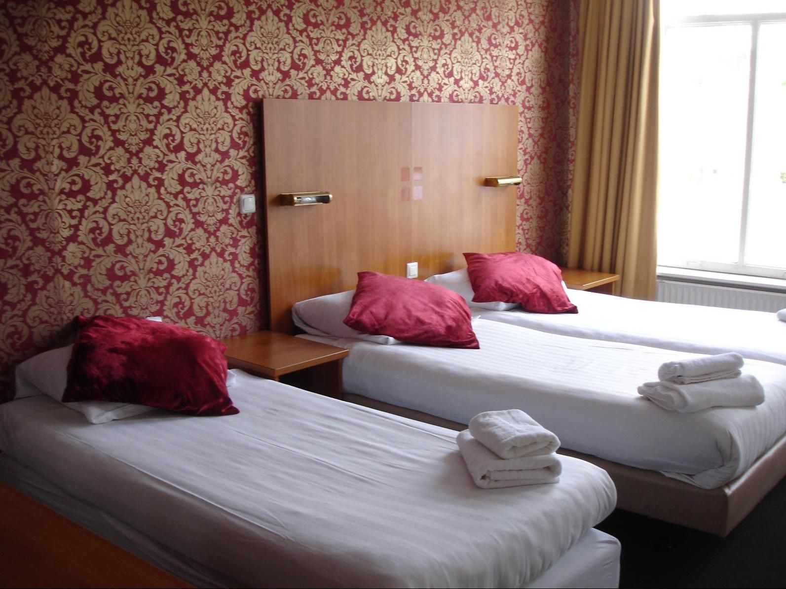 Hotel 74 Amsterdam room with two twin beds, red patterned wallpaper and window light